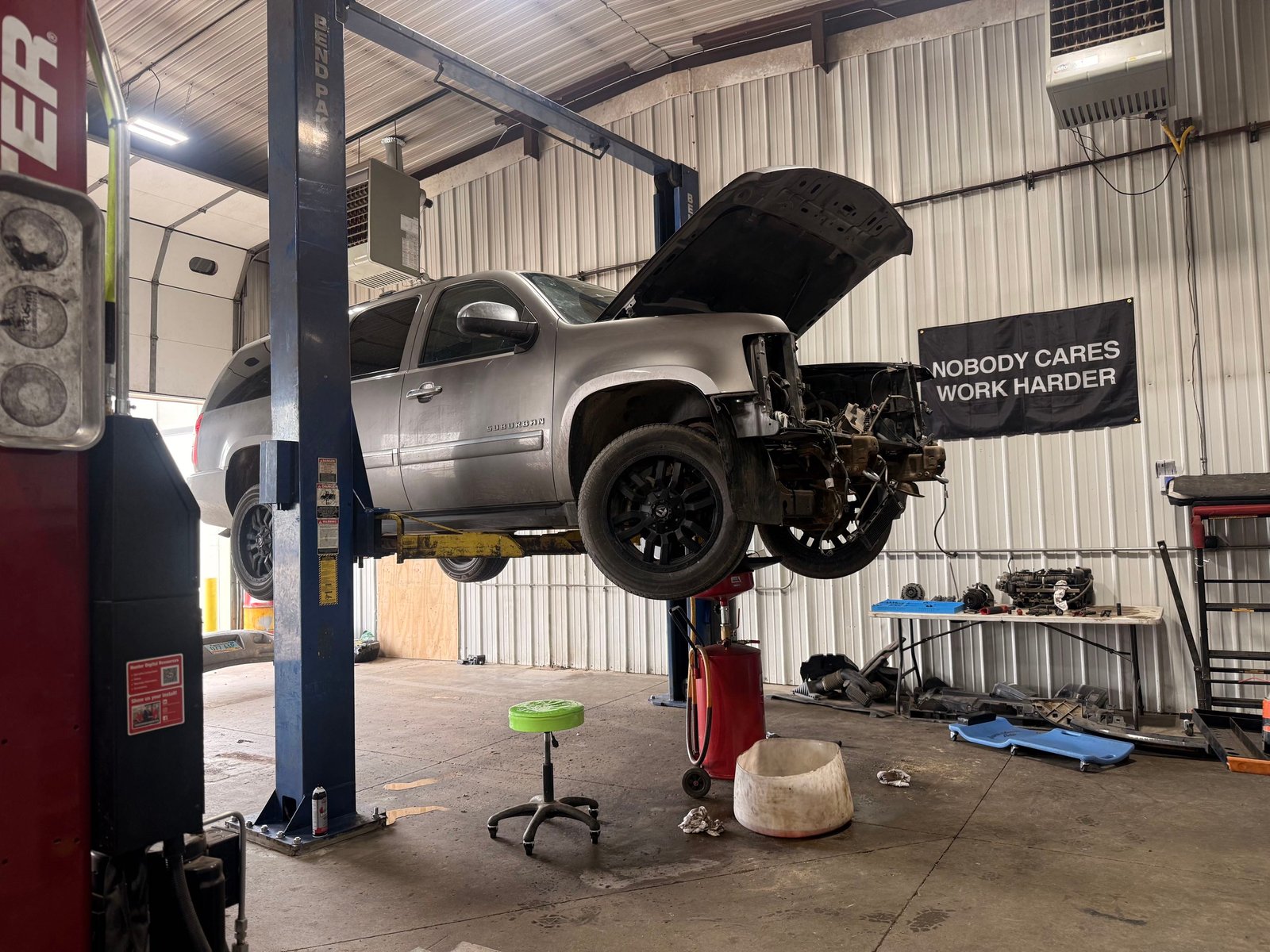 Silver SUV on a lift during engine repair at Precision Auto Repair