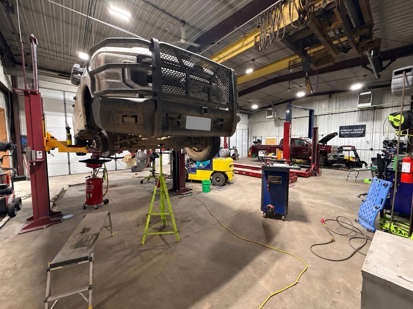 Truck on a lift inside the Precision Auto Repair shop